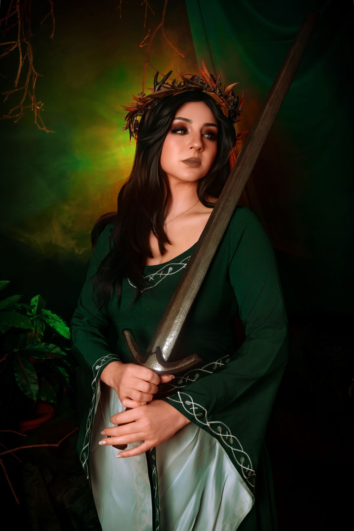 Cosplay elfa con corona e spada, fondo verde bosco