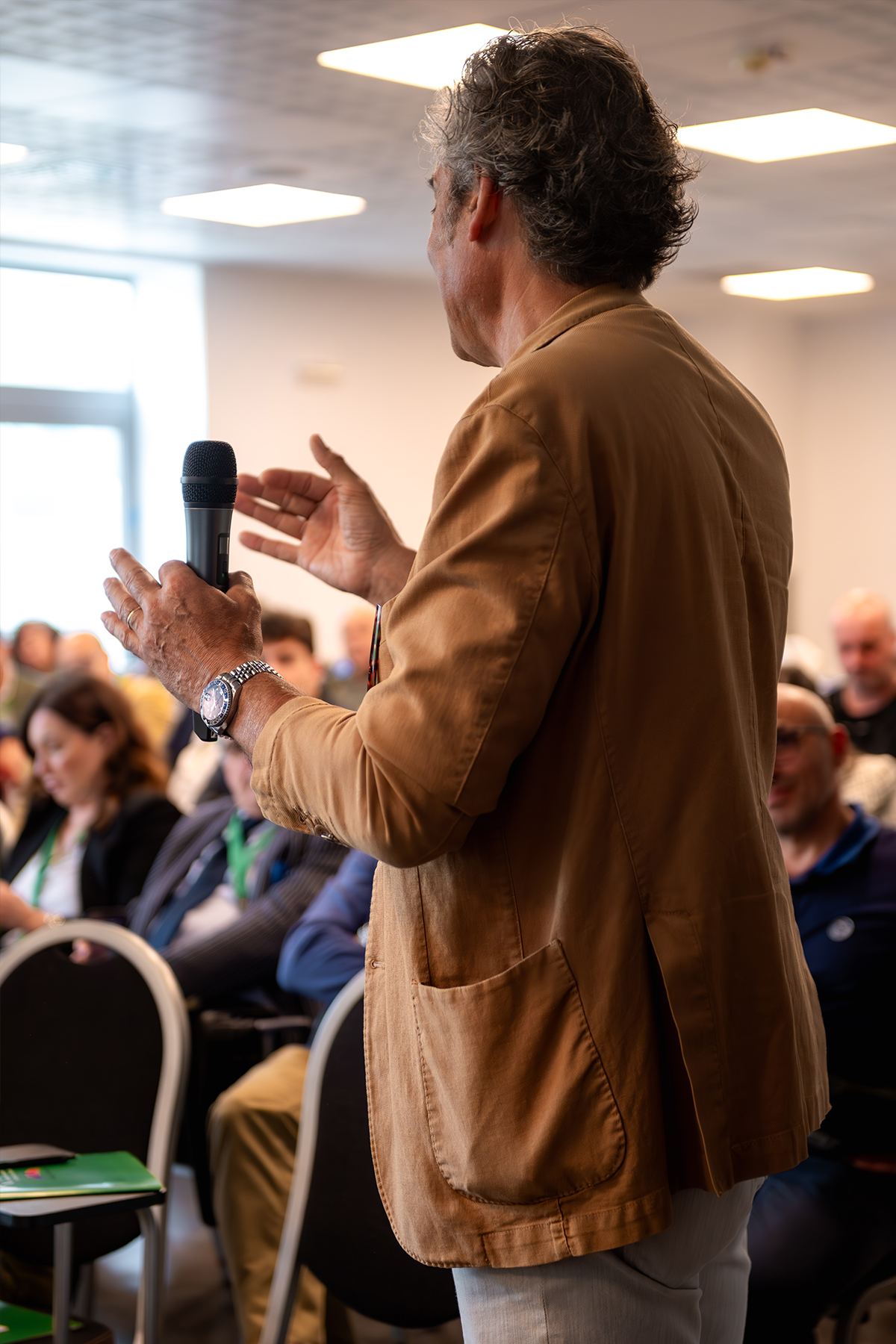 Ospite con microfono in piedi tra il pubblico