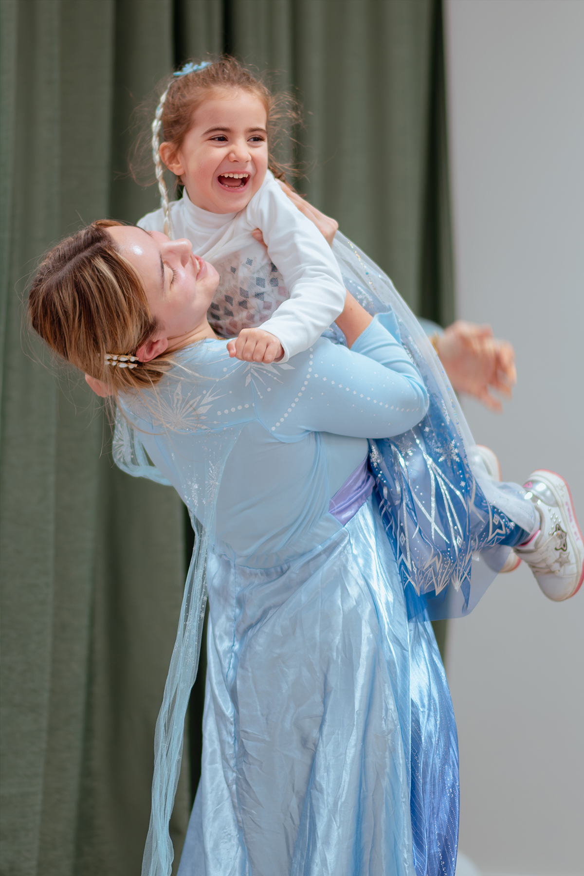 Bambina in costume sollevata dal papà durante una festa