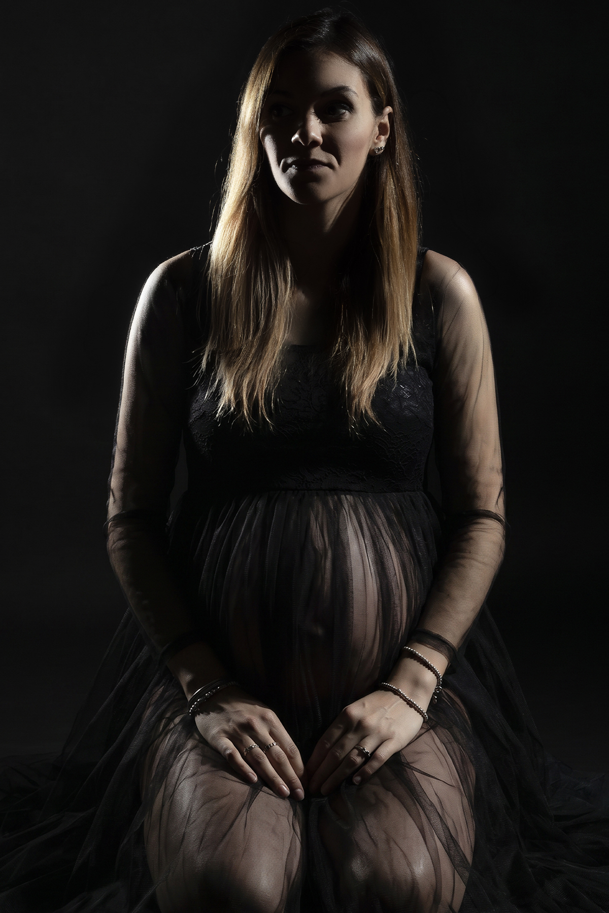 Donna incinta in nero, ritratto in chiaroscuro