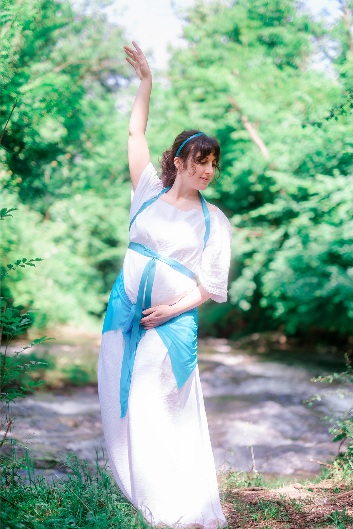 Donna incinta in vestito bianco, giardino all'aperto