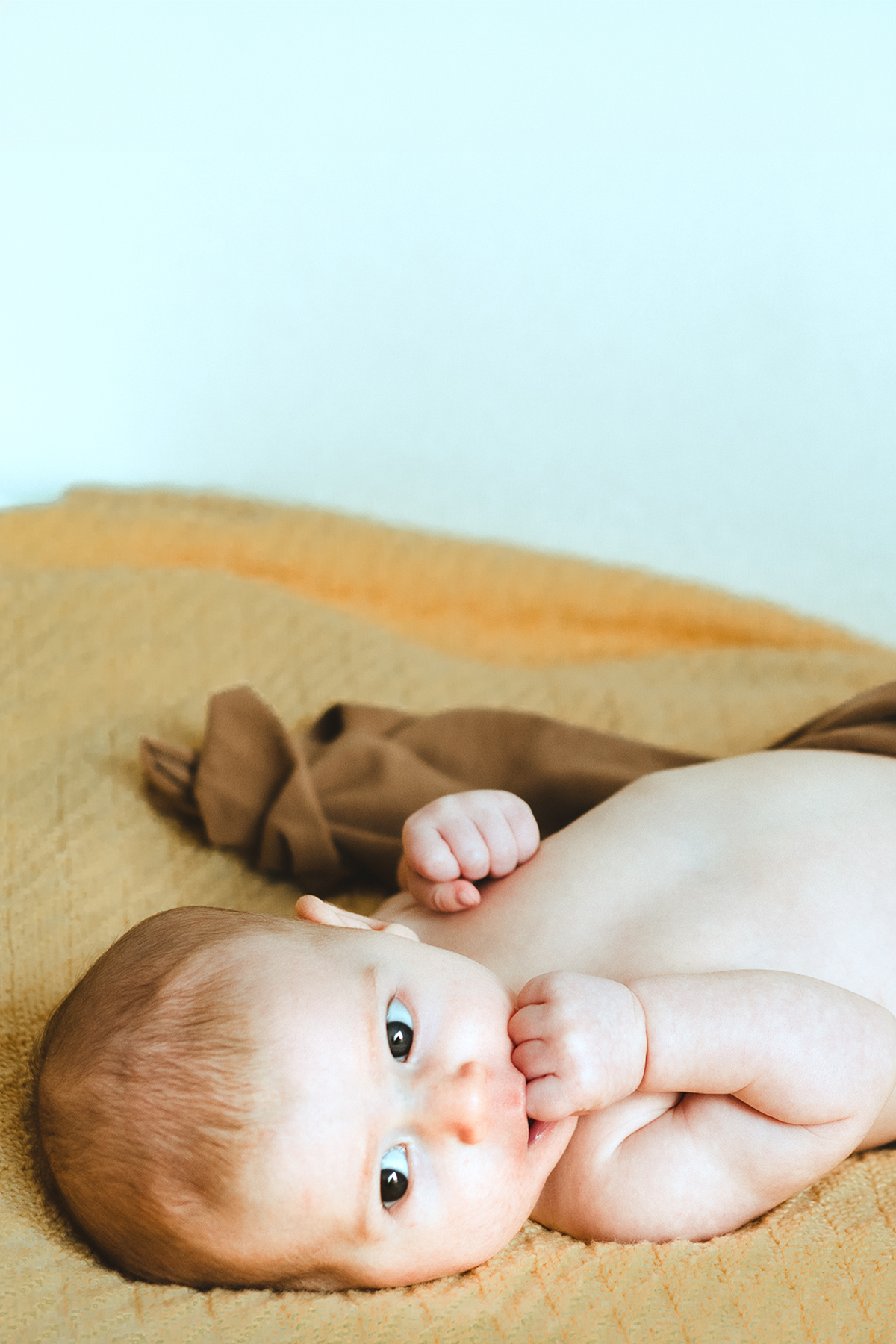 Neonato sdraiato su una coperta gialla