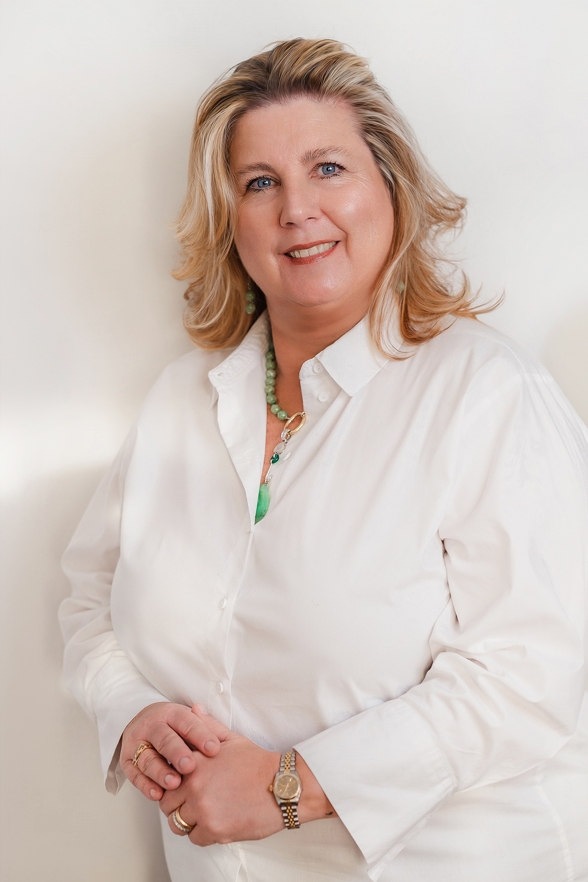Ritratto di donna bionda in camicia bianca su fondo bianco